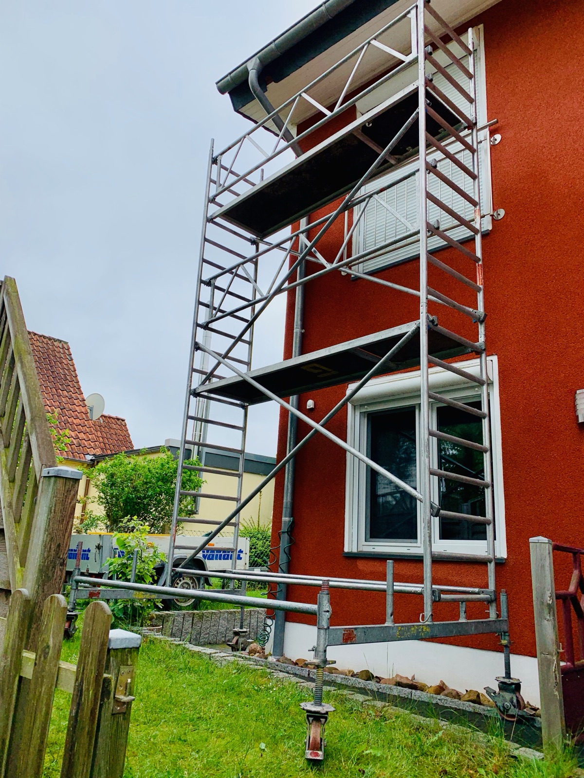 Rollgerüst an der Gartenseite eines roten Einfamilienhauses